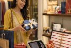 Woman selecting Rakhi gift hamper with festive presents and decorative rakhis