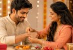 Sister tying Rakhi on brother during traditional Raksha Bandhan celebration with sweets.